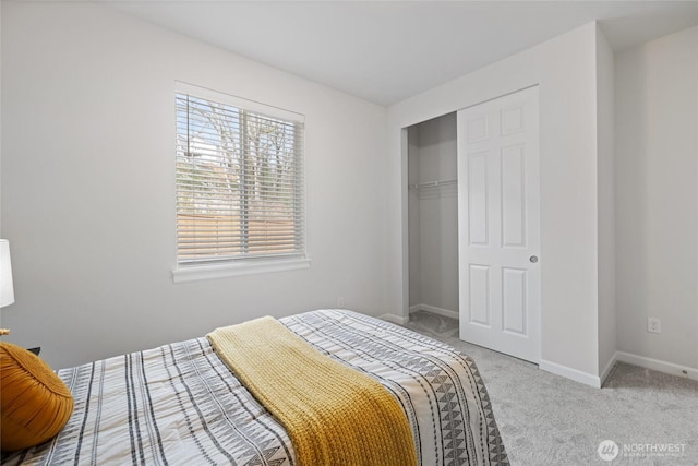 carpeted bedroom with a closet and baseboards