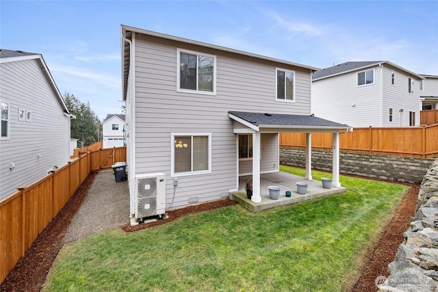 back of house with a fenced backyard, a lawn, and a patio