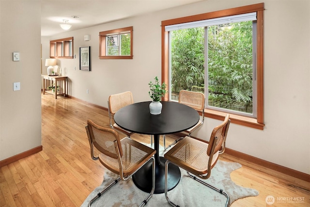 dining space with baseboards and light wood finished floors