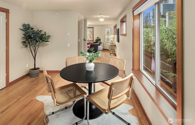 dining room with light wood finished floors and baseboards