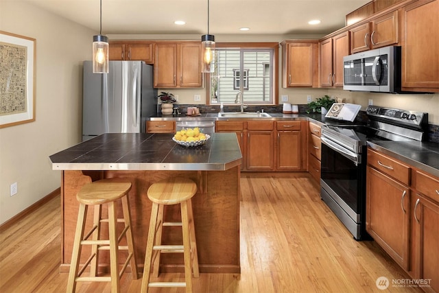 kitchen with a sink, stainless steel appliances, and brown cabinetry