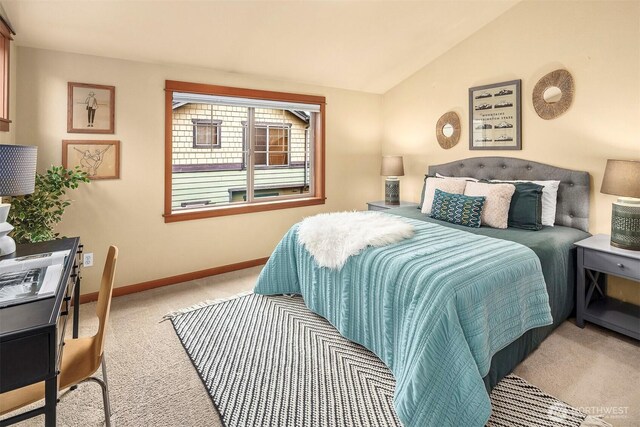 carpeted bedroom featuring baseboards and lofted ceiling