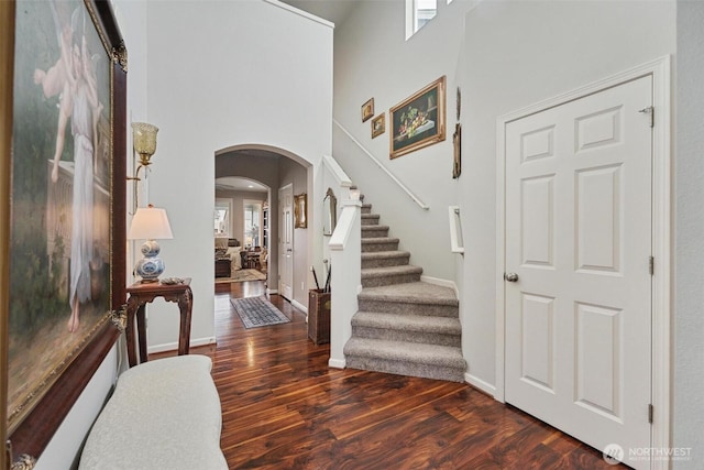 8107 165th Street Ct E, Puyallup, WA 98375 - foyer featuring stairs, a high ceiling, wood finished floors, baseboards, and arched walkways