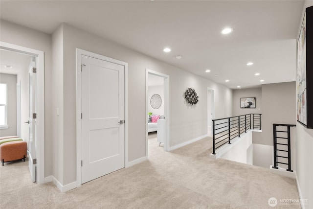 corridor featuring recessed lighting, baseboards, an upstairs landing, and carpet floors