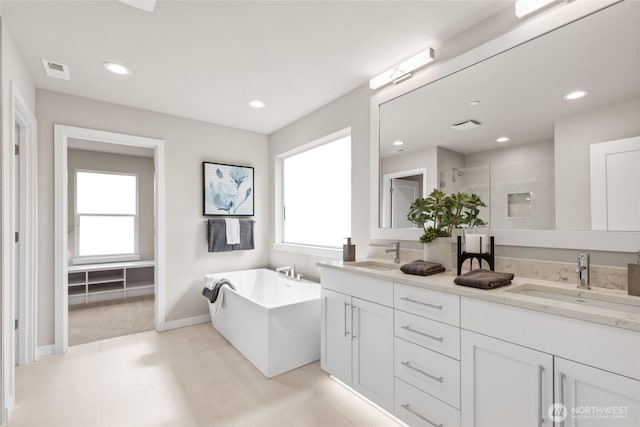 full bathroom with a stall shower, recessed lighting, visible vents, and a sink