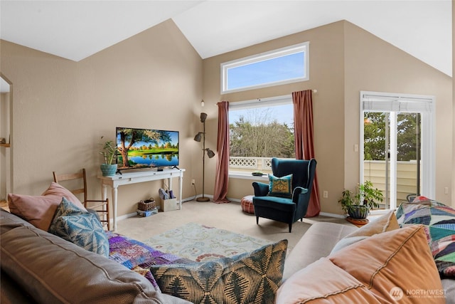 carpeted living room with lofted ceiling, baseboards, and arched walkways