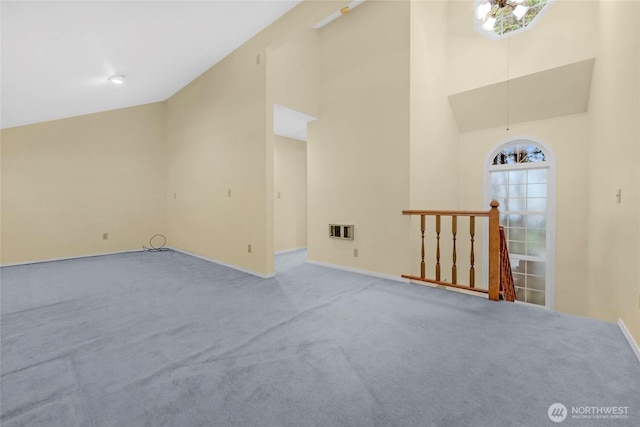 interior space with heating unit, baseboards, and high vaulted ceiling