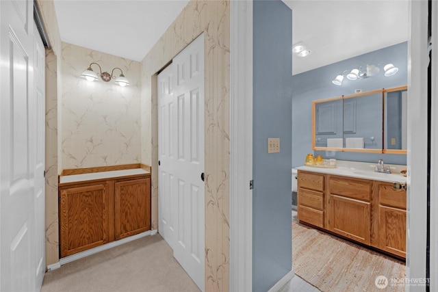 bathroom featuring wallpapered walls and vanity