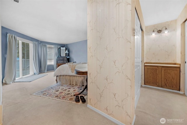 carpeted bedroom with visible vents, baseboards, and wallpapered walls