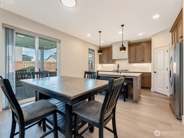 dining area with recessed lighting, a healthy amount of sunlight, and light wood-style floors