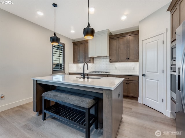 kitchen featuring a sink, stainless steel appliances, tasteful backsplash, and a breakfast bar