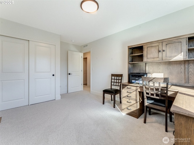 office area with visible vents, baseboards, and light colored carpet