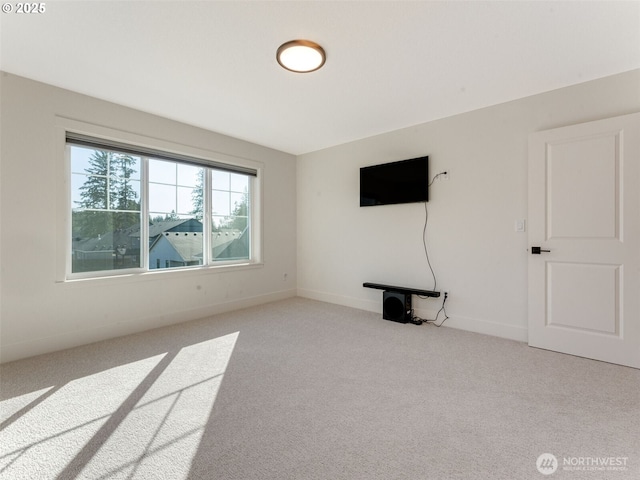 unfurnished living room with baseboards and carpet flooring