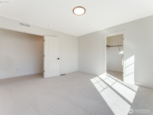 unfurnished bedroom with baseboards, visible vents, and light carpet