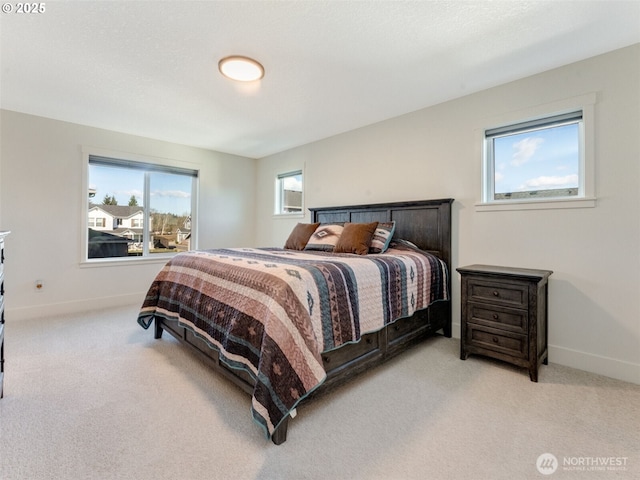 bedroom featuring light colored carpet and baseboards