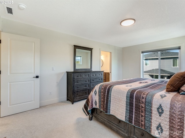 bedroom featuring visible vents, baseboards, light colored carpet, and connected bathroom