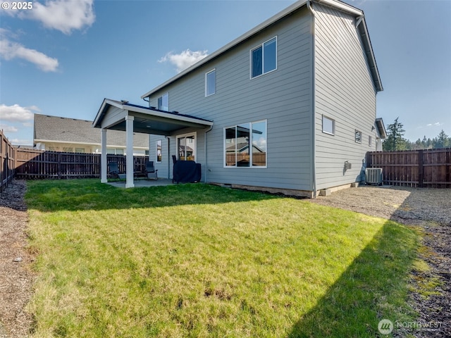 back of property with central air condition unit, a patio, a lawn, and a fenced backyard