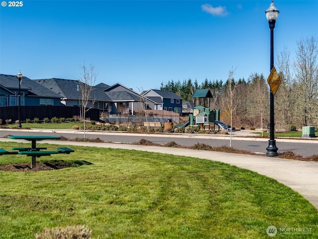 community playground with a residential view, a lawn, cooling unit, and fence