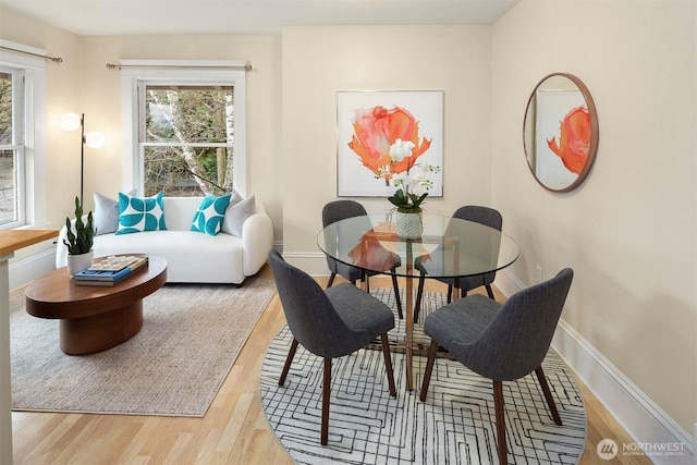 dining space featuring plenty of natural light, baseboards, and wood finished floors