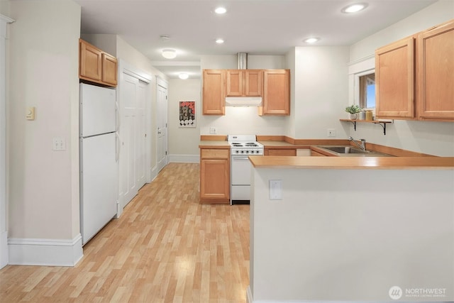 kitchen featuring under cabinet range hood, a peninsula, light wood-style floors, white appliances, and a sink