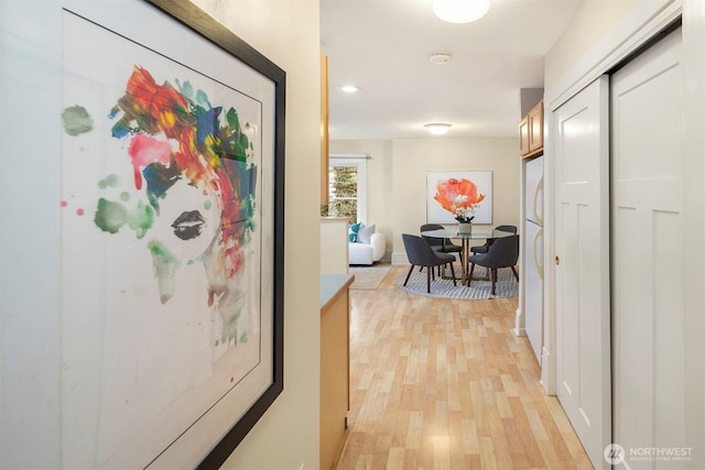 hall with baseboards and light wood-style floors