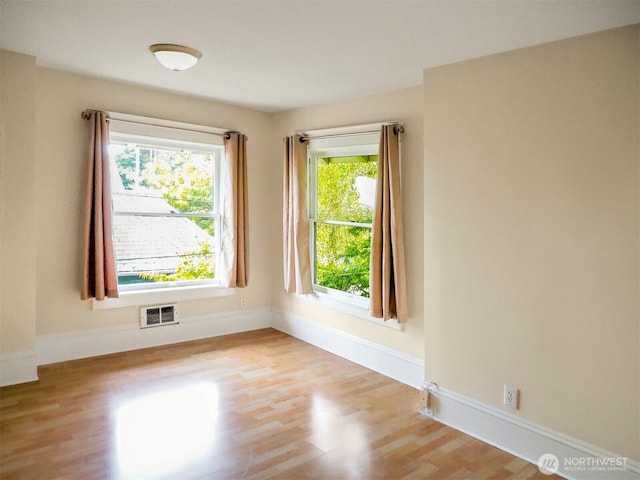 spare room with visible vents, plenty of natural light, and light wood-style flooring