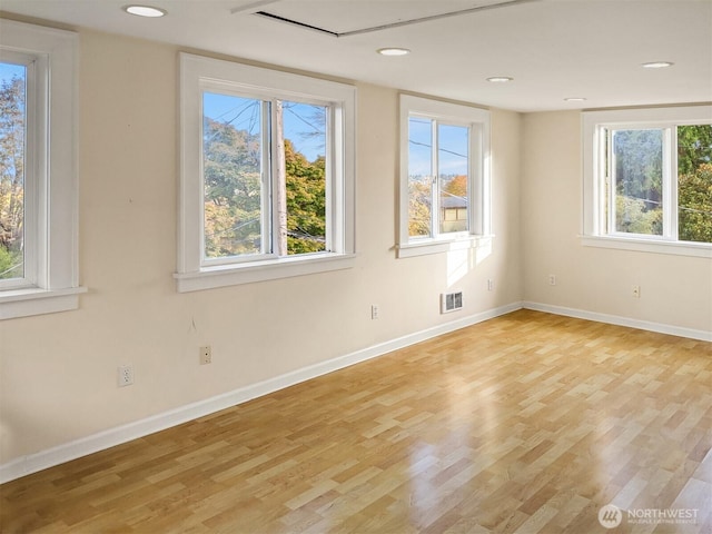 spare room featuring visible vents, baseboards, and light wood-style floors