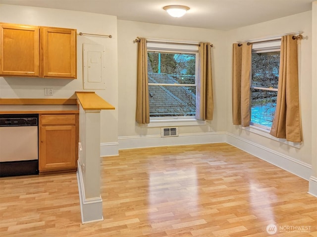 unfurnished dining area with electric panel, baseboards, and light wood finished floors