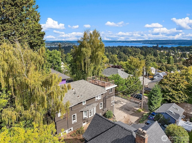 drone / aerial view with a forest view and a water view