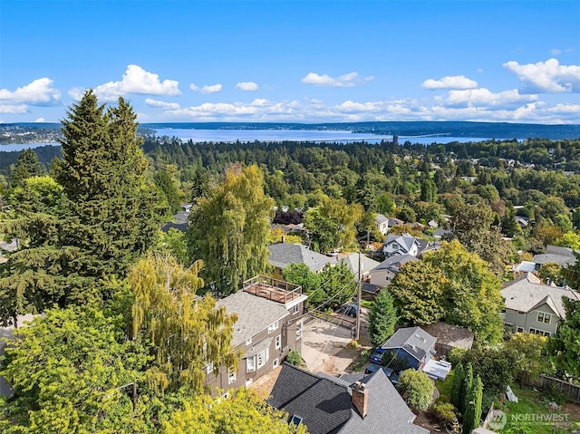 aerial view featuring a wooded view and a water view