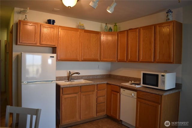 kitchen featuring a sink and white appliances