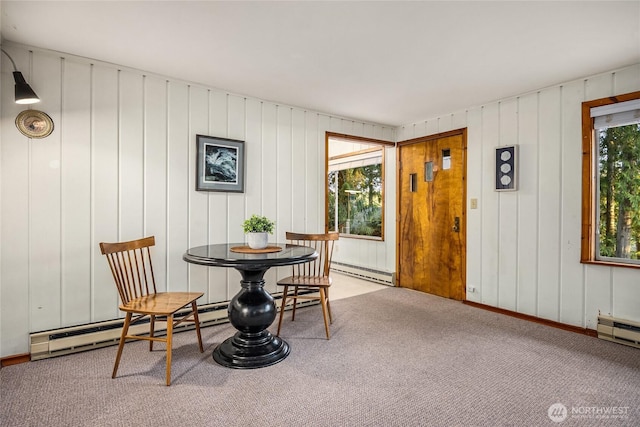 carpeted dining room with a baseboard heating unit, a wealth of natural light, and a baseboard radiator