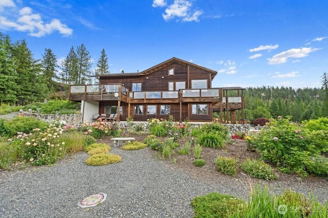 rear view of house featuring a wooden deck