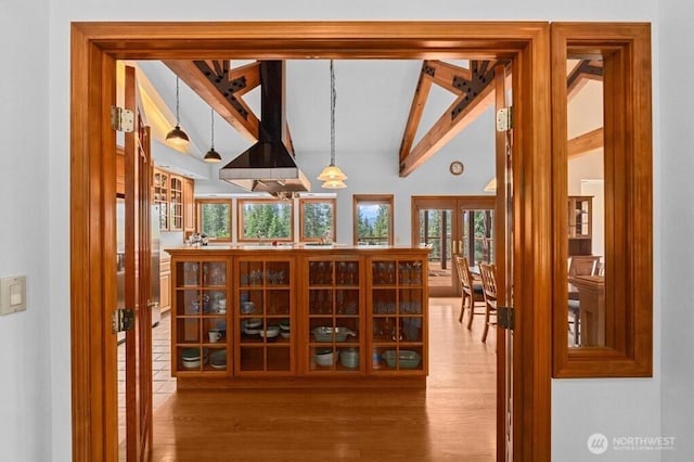 wine cellar featuring french doors, wood finished floors, and vaulted ceiling with beams