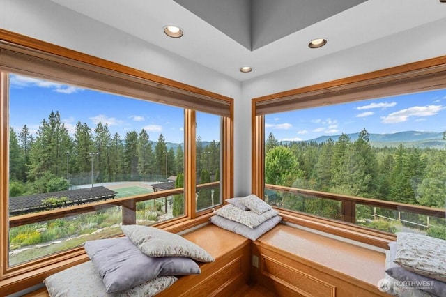 sunroom / solarium with a wooded view