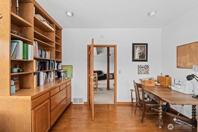 office area featuring visible vents, baseboards, and light wood-style floors