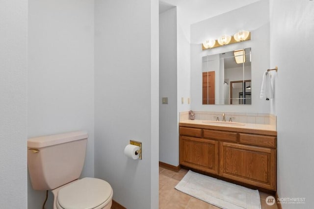 bathroom with vanity, tile patterned floors, toilet, and baseboards