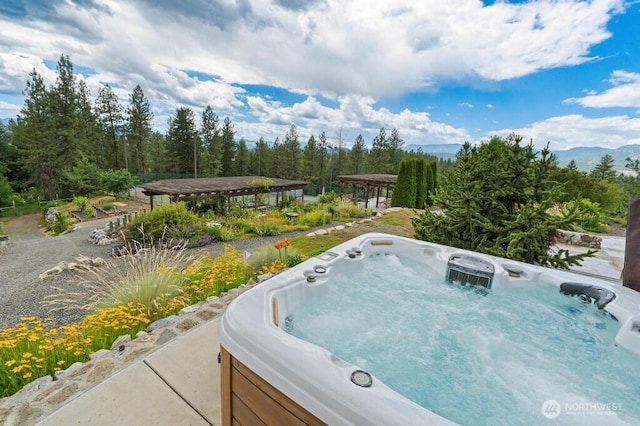 exterior space featuring a mountain view and a hot tub