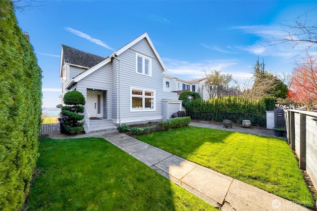 traditional home with a patio area, fence private yard, and a front lawn