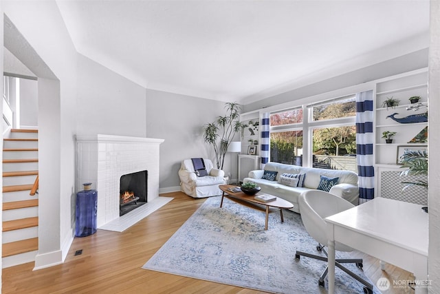 307 W Highland Dr, Seattle, WA 98119 - living area with stairway, a brick fireplace, baseboards, and wood finished floors