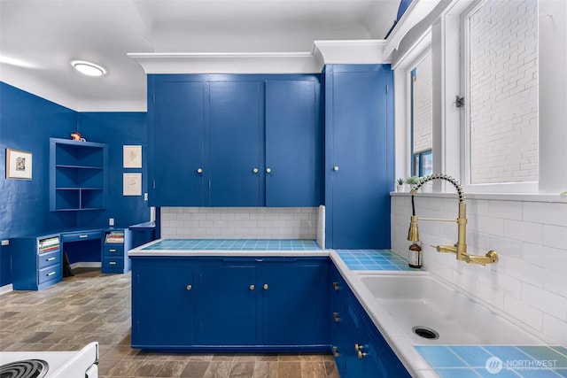 307 W Highland Dr, Seattle, WA 98119 - kitchen with a sink, blue cabinets, and backsplash