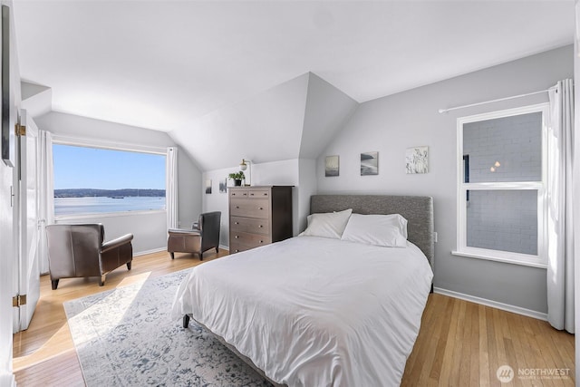 307 W Highland Dr, Seattle, WA 98119 - bedroom featuring vaulted ceiling, baseboards, and wood finished floors