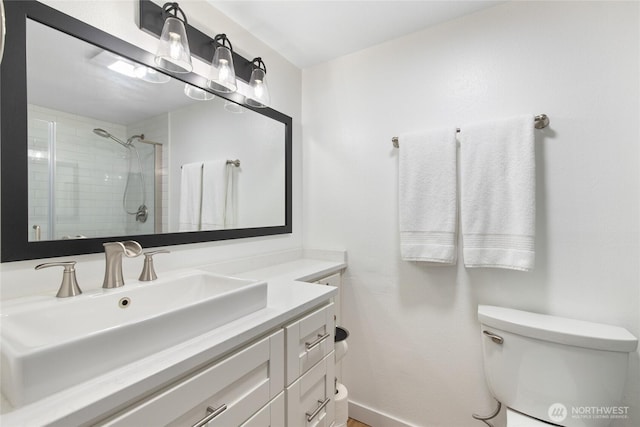 full bath featuring vanity, toilet, and tiled shower