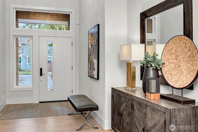 foyer entrance with wood finished floors and baseboards