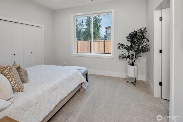 carpeted bedroom with a closet, baseboards, and visible vents