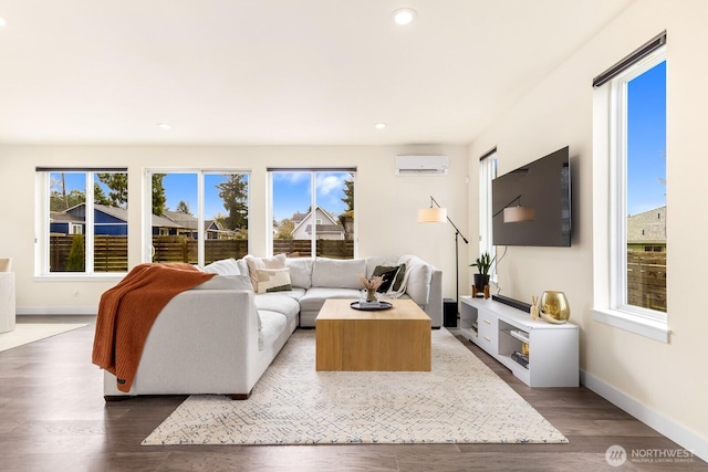 living room featuring recessed lighting, an AC wall unit, dark wood-style flooring, and a healthy amount of sunlight