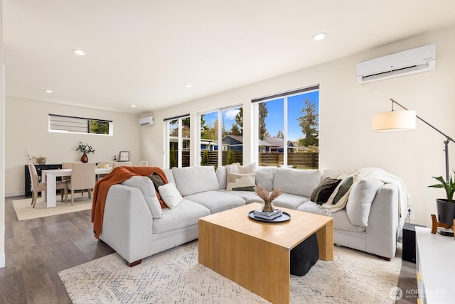 living area featuring an AC wall unit, recessed lighting, light wood-type flooring, and baseboards