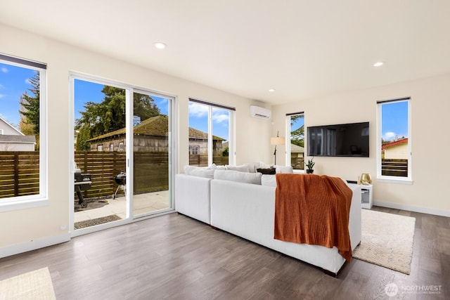 living room featuring recessed lighting, wood finished floors, baseboards, and a wall mounted air conditioner