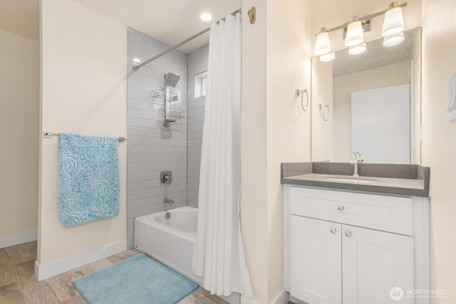 bathroom with vanity, wood finished floors, shower / bath combo, and baseboards