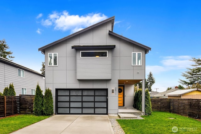 contemporary home with an attached garage, concrete driveway, a front lawn, and fence